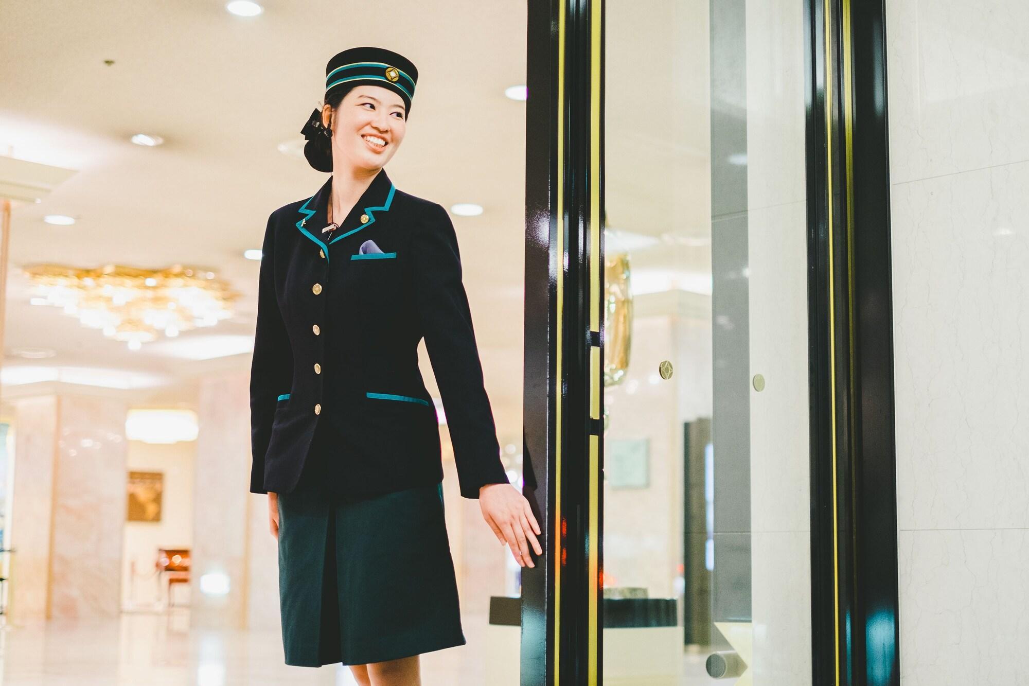 Hotel New Otani Hakata Фукуока Экстерьер фото A female doorman at the entrance of a hotel